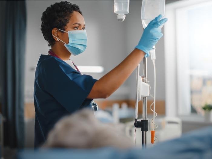 Enfermera revisando un suero en atención clínica